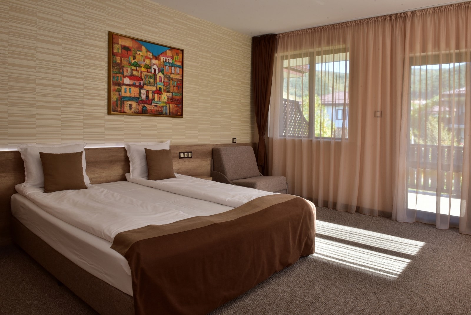 Bedroom at Villa Yustina Hotel with a double bed and a painting above the headboard